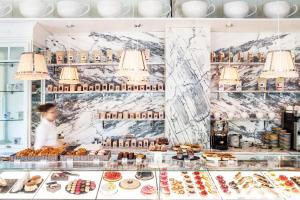 a woman standing behind a bakery counter with pastries at Ha(a)ïtza in Pyla-sur-Mer