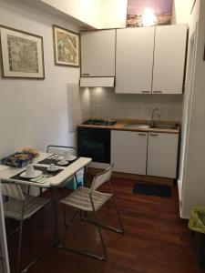 a kitchen with white cabinets and a table and chairs at La Casetta in Teramo