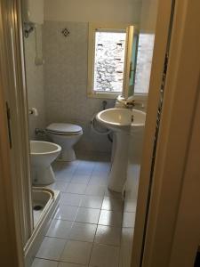 a bathroom with a sink and a toilet and a window at La Casetta in Teramo