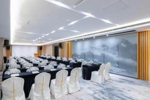 肇慶市にあるLonguu Hotel Zhaoqingの椅子が並び、大きなスクリーンがある部屋