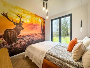 Un dormitorio con un cuadro de un ciervo en la pared. en Żurawia Kraina, 