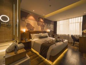 a bedroom with a large bed and a bath tub at James Joyce Coffetel Shenyang North Railway Station Qishan Road Metro Station in Shenyang