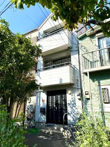 a white building with a black door at 横浜中華街,元町,山手エリア観光に最適,静かで62平米快適な一軒家,鎌倉へも好アクセス! in Yokohama