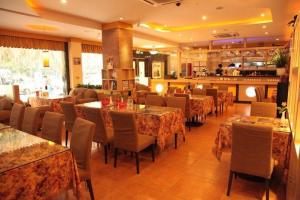 a dining room with tables and chairs in a restaurant at Hong Ye Hotel in Guangzhou
