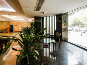 a lobby with chairs and plants in a building at Hong Ye Hotel in Guangzhou +102 photos