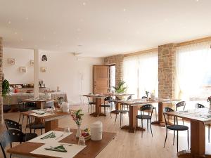a dining room with tables and chairs and windows at La Rocca in Carrù