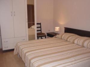 a bedroom with a large bed and a chair at Apartments Snježana in Sali