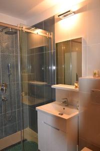 ママイアにあるMamaia Solid House Residence 2のバスルーム(シャワー、洗面台、ガラス張りのシャワーブース付)