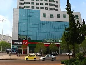 a large glass building with cars parked in front of it at GreenTree Inn Rizhao Train Station in Rizhao