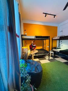 einem Mann, der in einem Zimmer mit Etagenbetten sitzt in der Unterkunft Himtrek Stays Katagala in Kasol