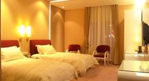 a hotel room with two beds and a mirror at Tomolo Hotel Wuzhan Branch in Wuhan