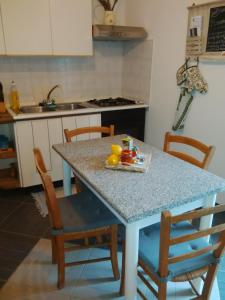 una cocina con una mesa con sillas y una mesa con frutas. en Da Laura e Sergio, en Vezzi Portio