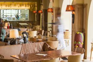 a person walking in a restaurant with tables and chairs at Ha(a)ïtza in Pyla-sur-Mer