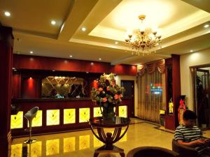 a lobby with a table with a vase of flowers at GreenTree Inn Zhangjiakou Jinding Ci’er Mountain Road Business Hotel in Zhangjiakou