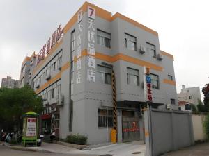 a white building with an orange stripe on a street at 7 Days Premium Haiyan New Bridge South Road Branch in Haiyan