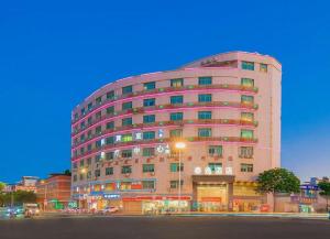 a large pink building with a street in front of it at GreenTree Inn GuangDong Shantou Jinping District Leshan Road Business Hotel in Xialian