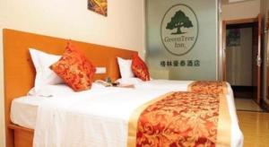 a hotel room with two beds with red and orange pillows at GreenTree Inn LangFang YanJiao Tianyang Plaza Express Hotel in Gaolou