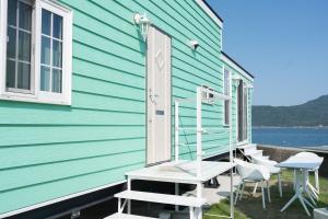 a house with a porch with chairs and a ladder at 宮島リゾート Hauol'i in Hatsukaichi