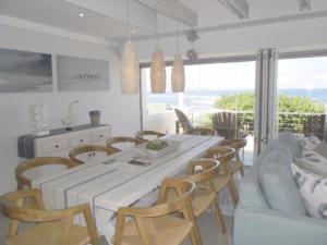 a kitchen and dining room with a white table and chairs at Whale Rock 54 in Hermanus