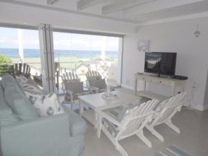 a living room with a white couch and a television at Whale Rock 54 in Hermanus