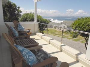 a balcony with chairs and a view of the ocean at Whale Rock 54 in Hermanus