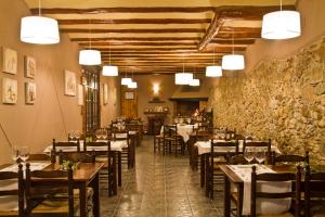 a restaurant with tables and chairs in a room at Cal Barber in Botarell