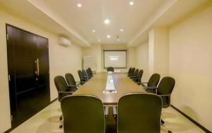 een conferentieruimte met een lange tafel en stoelen bij Tab Hotel Surabaya in Surabaya