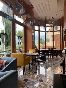 a restaurant with tables and chairs and windows at The Pema by Realm in Thimphu