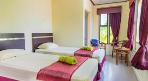 a hotel room with two beds and a window at Nipah River view in Kampong Losong