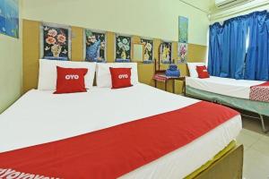 a bedroom with two beds with red and white pillows at SPOT ON 90625 Super Green Grass Hotel in Yong Peng