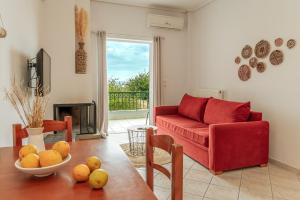 ein Wohnzimmer mit einem roten Sofa und einem Tisch in der Unterkunft Gregory's House in Monemvasia