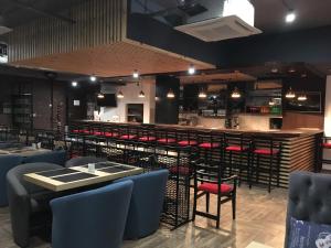 a restaurant with a bar with red chairs at Hotel Florida in Kyiv