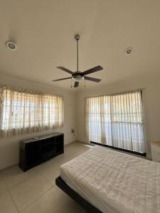 une chambre avec un lit et un ventilateur de plafond dans l'établissement Casa Mango, à Conchal