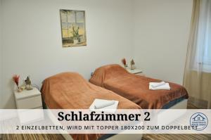 zwei Einzelbetten in einem Zimmer mit einem Poster in der Unterkunft Apartment Karin - Modern ausgestattet und ideal für Gruppen bis 6 Personen und Hund, egal ob Familie, Kollegen oder Freunde, 85qm mit Terasse und eigenem Stellplatz in Riegelsberg