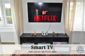 einen TV an einer Wand mit einem Netflix-Schild drauf in der Unterkunft Apartment Karin - Modern ausgestattet und ideal für Gruppen bis 6 Personen und Hund, egal ob Familie, Kollegen oder Freunde, 85qm mit Terasse und eigenem Stellplatz in Riegelsberg + 16 Fotos