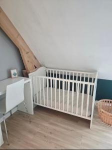 un berceau blanc dans une pièce avec un escalier dans l'établissement Les sables, à Le Touquet-Paris-Plage