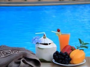 a table with fruit and a drink next to a pool at Khaoyai Nature Life & Tour Resort in Nong Nam Daeng