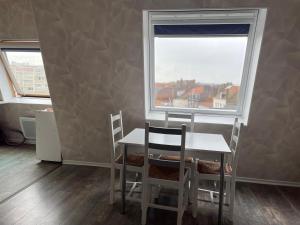 加来Grand studio Centre-ville avec ascenseur的一间有桌子、椅子和窗户的餐厅 更多1张照片