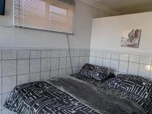 een bed in een kamer met twee kussens erop bij Lion's Cave 1B in Mosselbaai