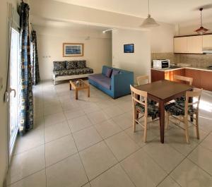 a living room with a table and a blue couch at 4S Beach Superior Apartments in Stalís