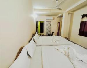a bedroom with two beds and a ceiling fan at Hotel Luxury Heaven in Deoghar