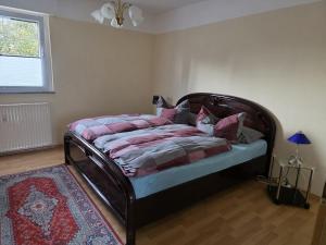 a bedroom with a bed with a wooden headboard at Ferienwohnung Beate & Burkhard in Oberhausen