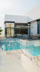 a large swimming pool with blue water in a house at Hummingbird Rak in Ras al Khaimah +67 photos