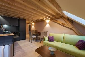 a living room with a green couch and a kitchen at Casa Cosí in Luxembourg