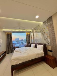 a bedroom with a large bed and a large window at Hotel Amora Royale in Jāmb +16 photos