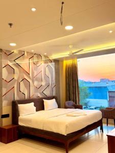 a bedroom with a bed and a large window at Hotel Amora Royale in Jāmb