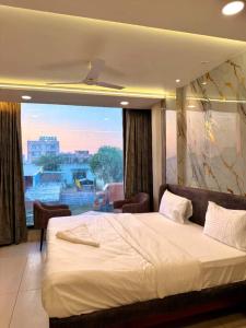 a bedroom with a large bed and a large window at Hotel Amora Royale in Jāmb