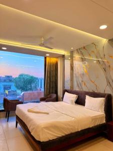 a bedroom with a large bed and a large window at Hotel Amora Royale in Jāmb