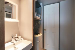 a bathroom with a sink and a mirror and a door at THE KAMAKURA＋LIVING - Vacation STAY 62510v in Kamakura +24 photos