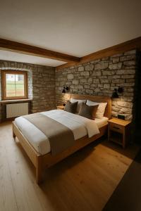 a bedroom with a large bed and a brick wall at Chalet Bauernhaus 1864 in Elbigenalp